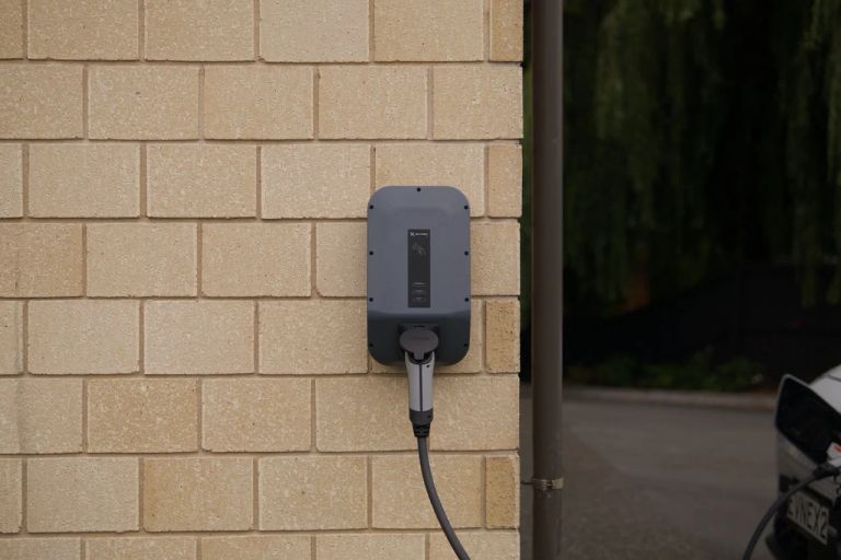An einer Hauswand installierte Wallbox-Ladestation für Elektrofahrzeuge